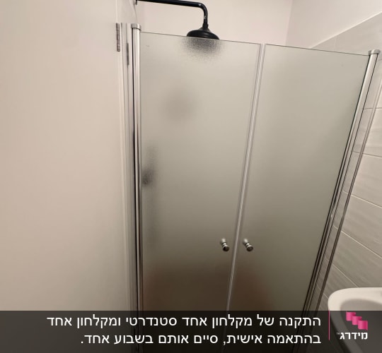 מקלחון עם דלתות זכוכית ומקלחת שחורה
